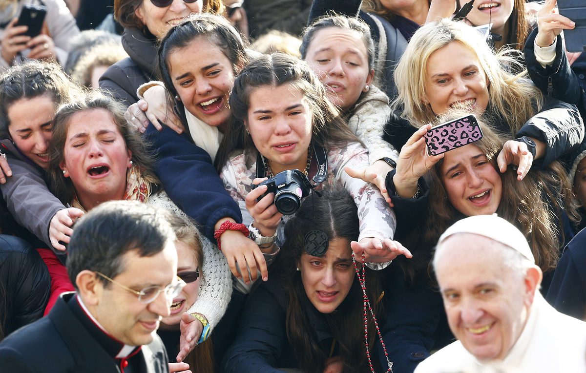 Faithful greet Pope Francis as he arrives to lead the weekly audience in Saint Peter's Square at the Vatican