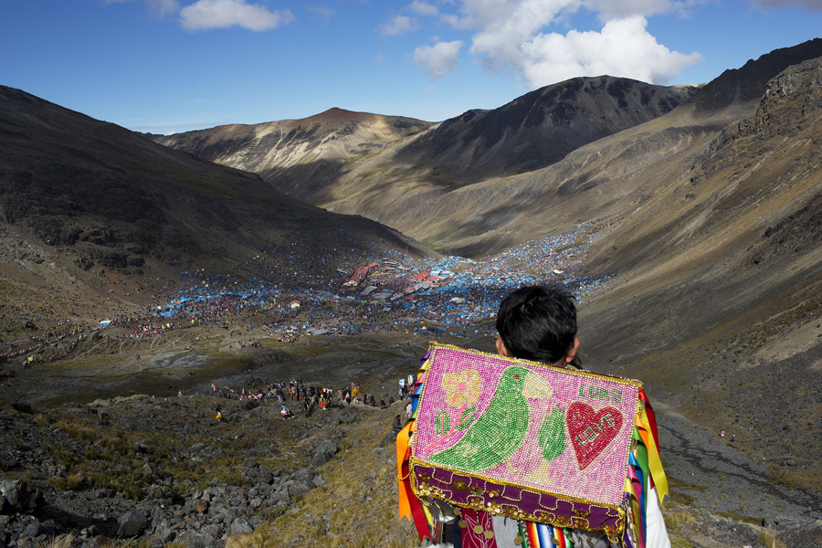 In this May 24, 2016 photo, a young boy descends the Qullqip'unqu mountain looking out at the tens of thousands of pilgrims gathered to celebrate the three-day festival Qoyllur Rit’i, translated from the Quechua language as Snow Star, in the Andean Sinakara Valley, in Peru's Cusco region. The celebration that mixes Catholic and indigenous beliefs honors Jesus as well as the area’s glacier, which is considered sacred among some indigenous people. While the native celebration is far older, the Christian part of the ritual stretches back to the 1700s, when Jesus is said to have appeared to a young shepherd in the form of another boy. (AP Photo/Rodrigo Abd)