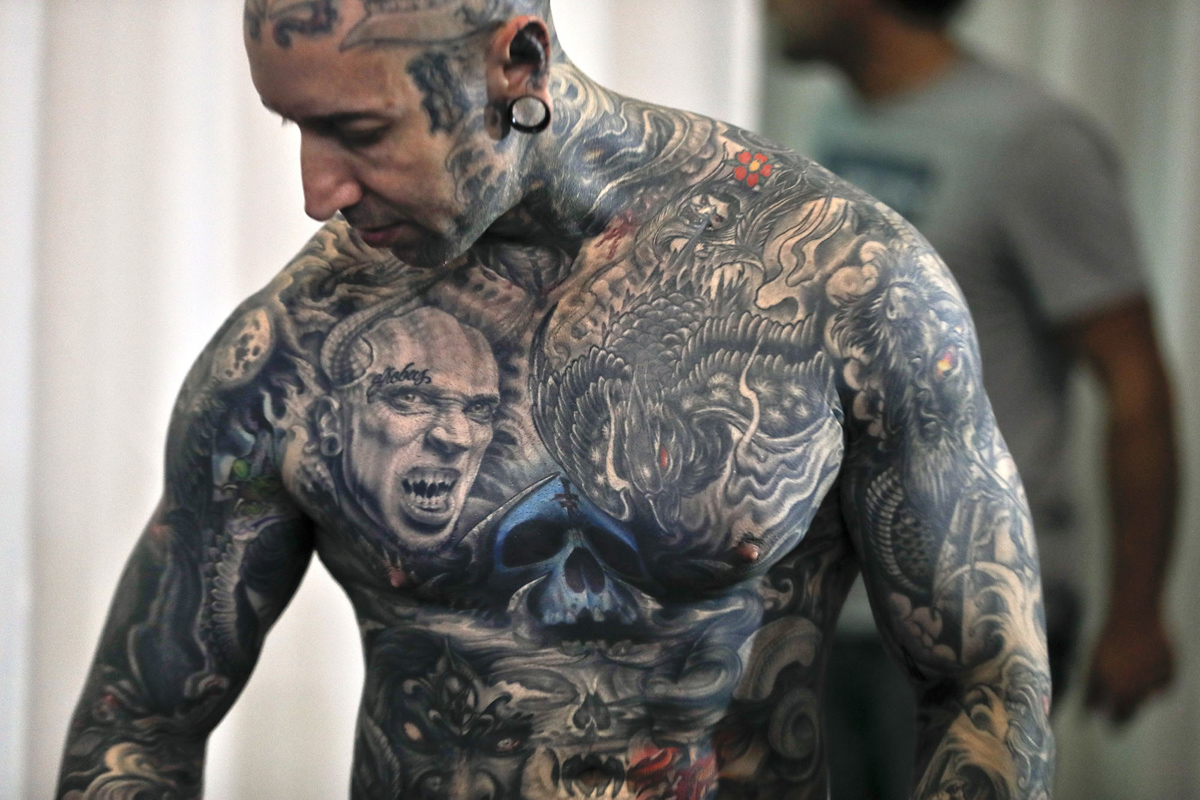 A man shows his tattoos during the International Tattoo Convention Bucharest 2016 in Bucharest, Romania, Sunday, Oct. 16, 2016. Prominent tattoo artists from across the world displayed their skills in the Romanian capital over the weekend. (AP Photo/Vadim Ghirda)